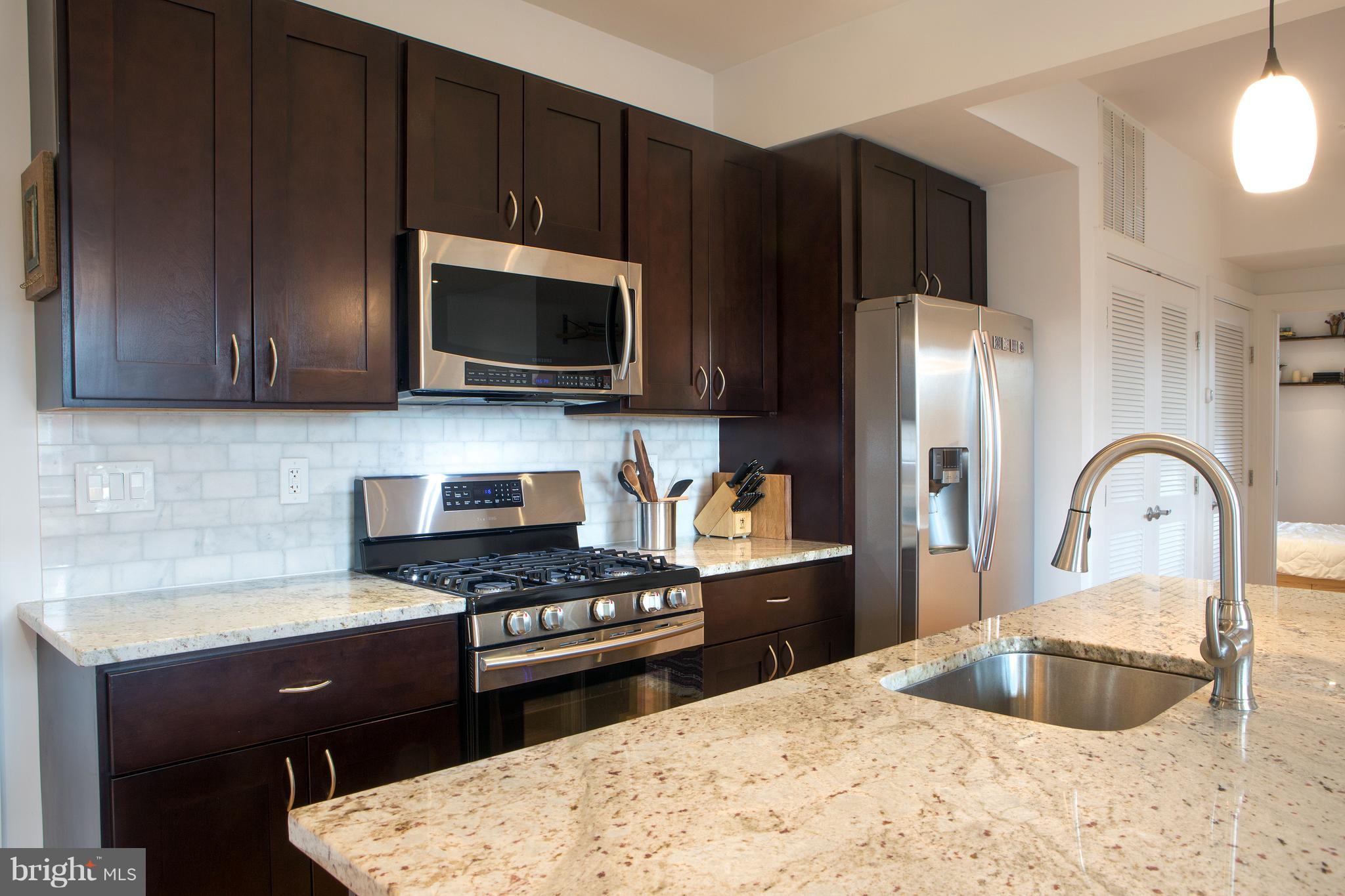 1700 2nd Street Northwest, Unit 9 Washington, DC 20001 - Photo 6 of 26 a kitchen with granite countertop a stove a sink and a microwave