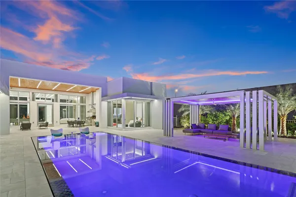 an aerial view of a house with a yard swimming pool and outdoor seating