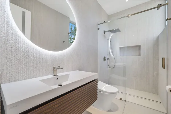 a bathroom with a granite countertop shower a sink and a toilet