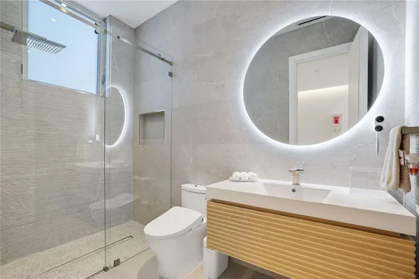 a bathroom with a sink toilet vanity and shower