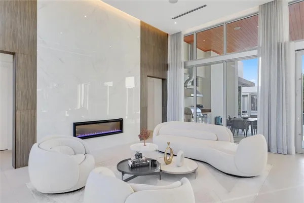 a living room with furniture kitchen view and a large window