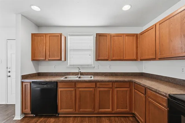 a kitchen with granite countertop a sink cabinets and window