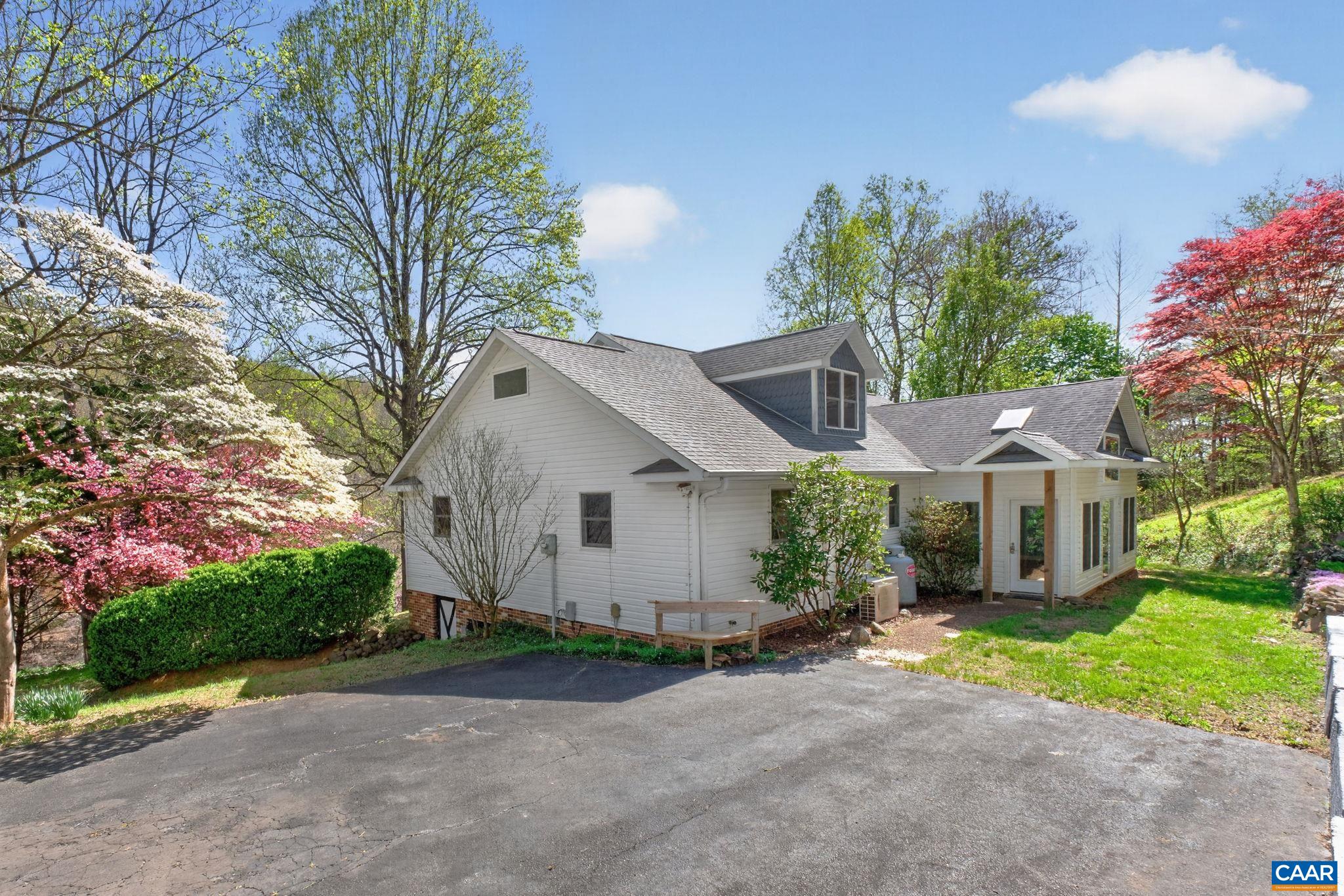 689 Mutton Hollow Road Stanardsville, VA 22973 - Photo 16 of 61 a front view of a house with a garden and trees