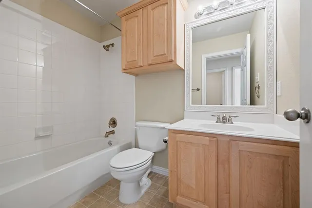 a bathroom with a granite countertop toilet a sink and bathtub