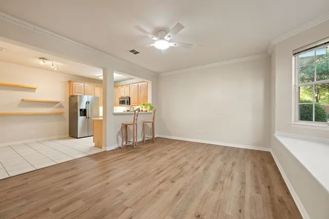 a view of a kitchen with wooden floor and a ceiling fan