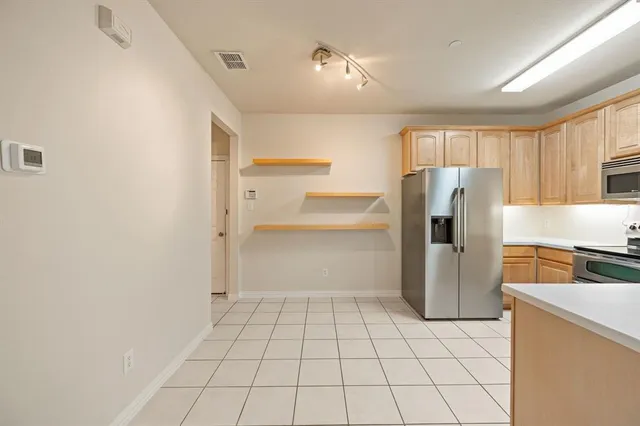 a kitchen with white cabinets and refrigerator