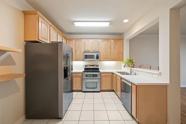 a kitchen with stainless steel appliances granite countertop a refrigerator and a stove top oven