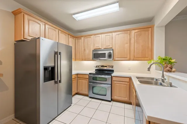 a kitchen with a refrigerator a sink a stove a microwave and cabinets