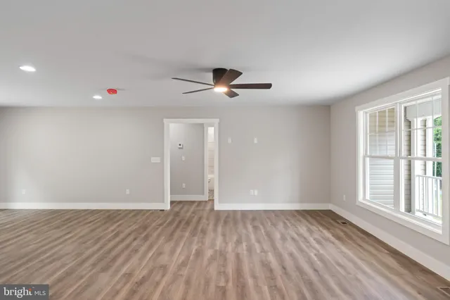 a large white kitchen with wooden floors and white walls
