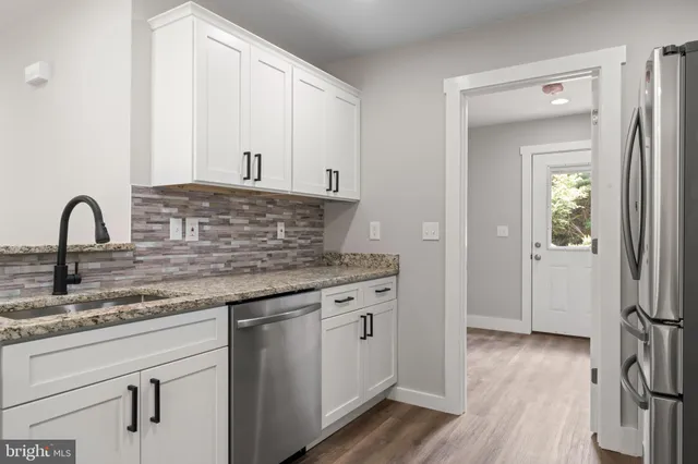 a view of a room with wooden floor and ceiling fan