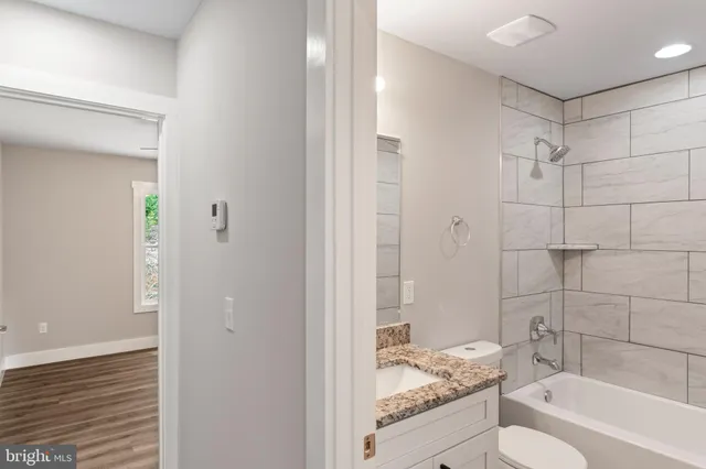 a view of a house with wooden roof and a large tree