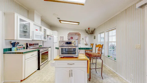 a kitchen with stainless steel appliances kitchen island granite countertop a stove and a sink
