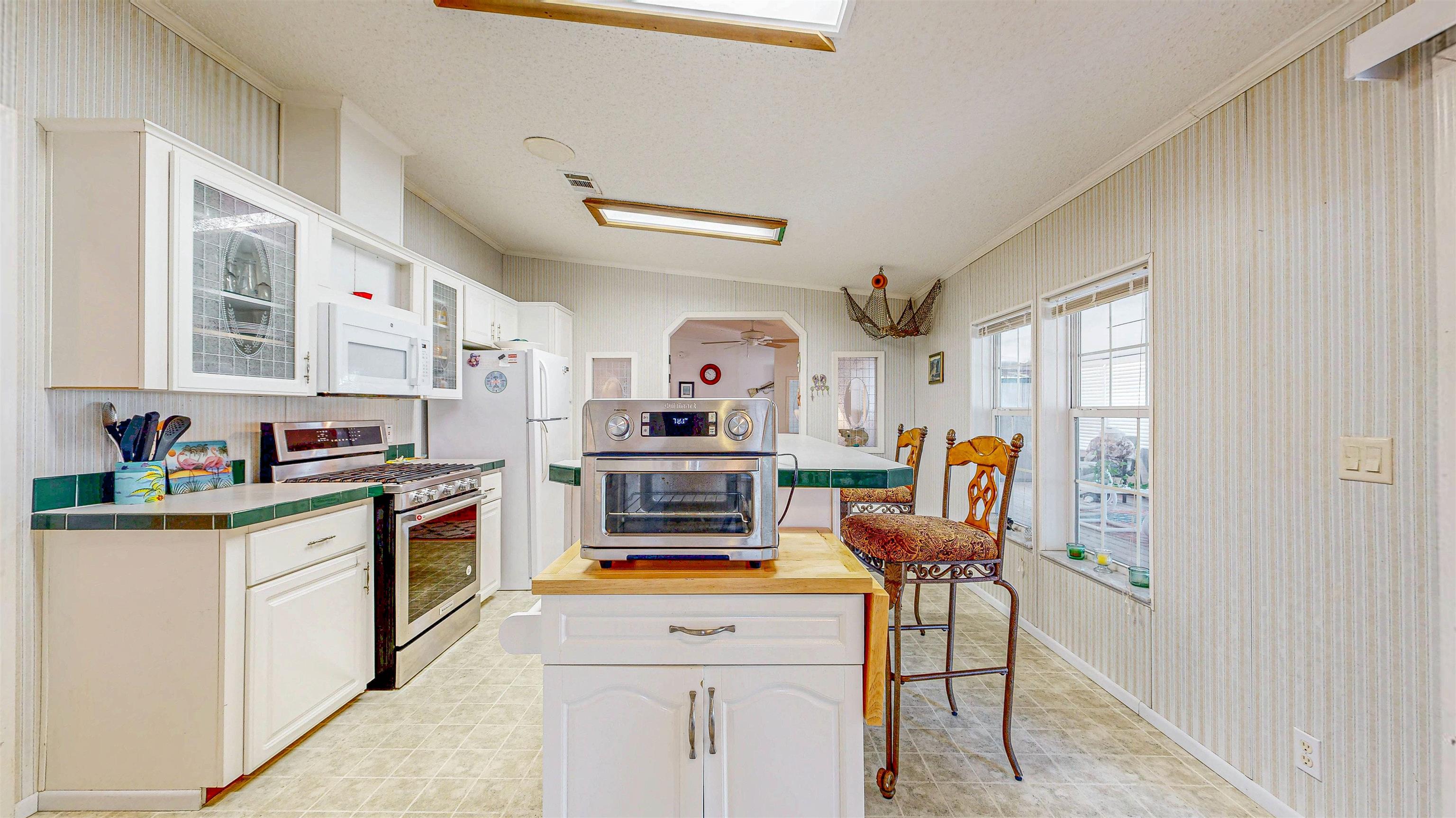 8825 A1A South St. Augustine, FL 32080 - Photo 11 of 20 a kitchen with stainless steel appliances kitchen island granite countertop a stove and a sink