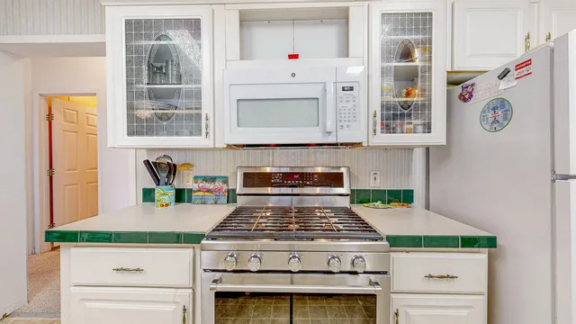 a white stove top oven sitting inside of a kitchen