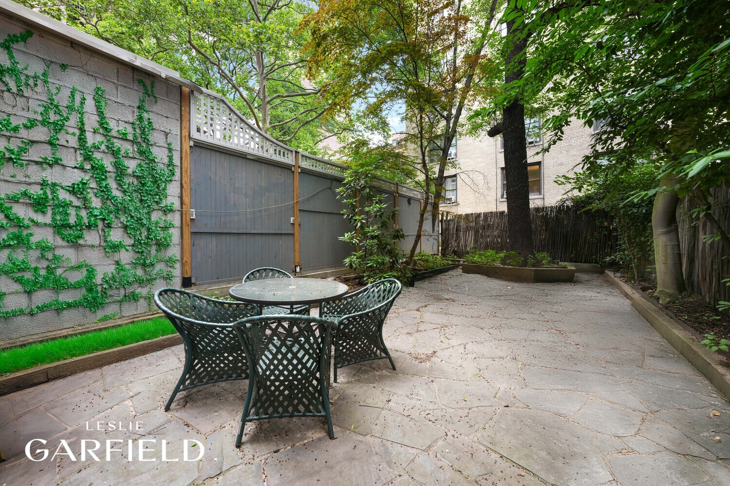 251 East 71st Street Manhattan, NY 10021 - Photo 8 of 10 a view of backyard with table and chairs and a large tree