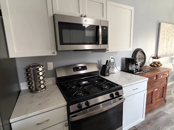 a kitchen with stainless steel appliances granite countertop a stove a microwave and cabinets