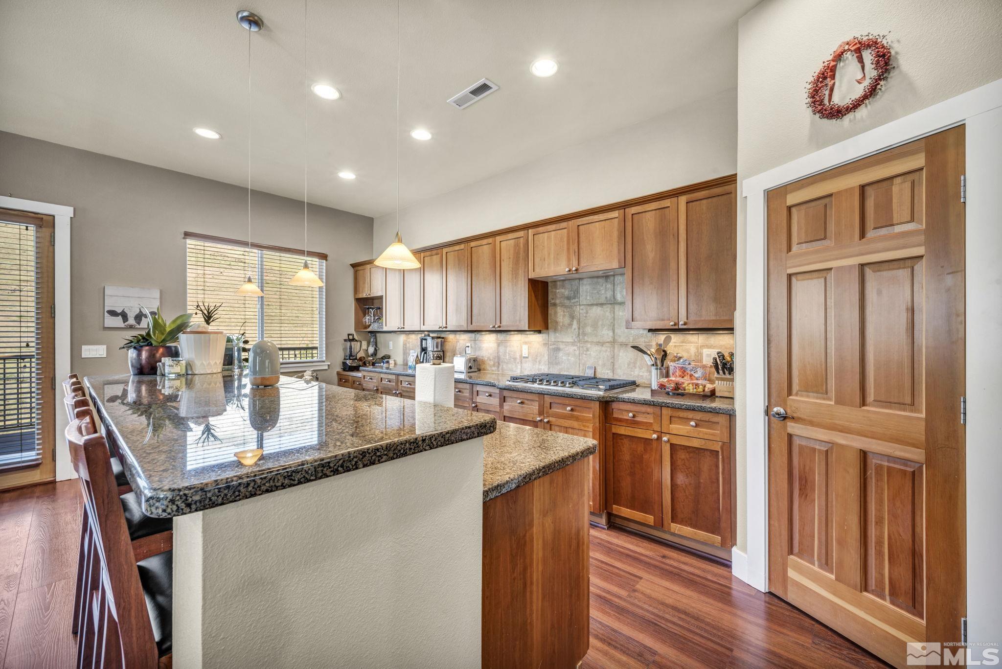 4975 Turning Leaf Way Reno, NV 89519 - Photo 6 of 40 a kitchen with stainless steel appliances granite countertop a stove a sink dishwasher and a refrigerator with wooden floor
