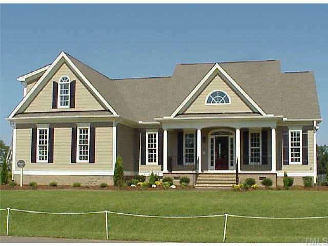 a view of a brick house with large windows and a big yard