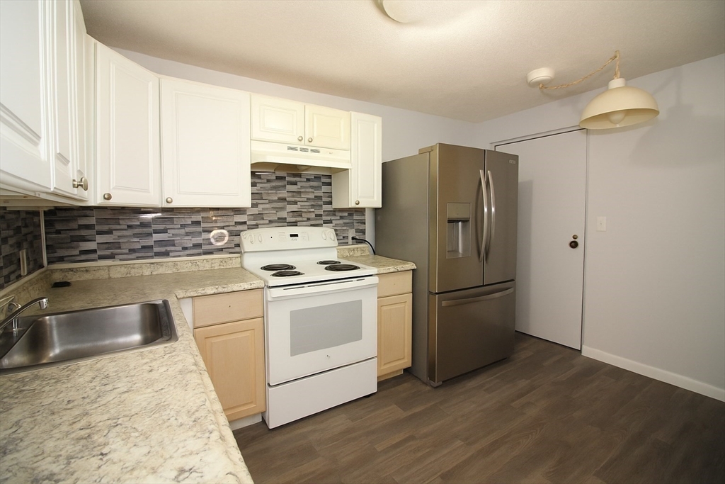 305 Riverside Avenue, Unit 41 Medford, MA 02155 - Photo 7 of 12 a kitchen with a refrigerator sink and cabinets