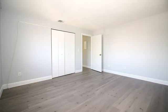 a view of an empty room with wooden floor