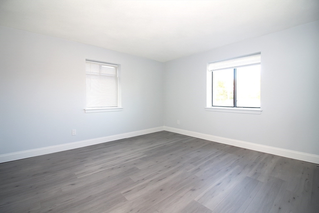305 Riverside Avenue, Unit 41 Medford, MA 02155 - Photo 9 of 12 an empty room with wooden floor and windows