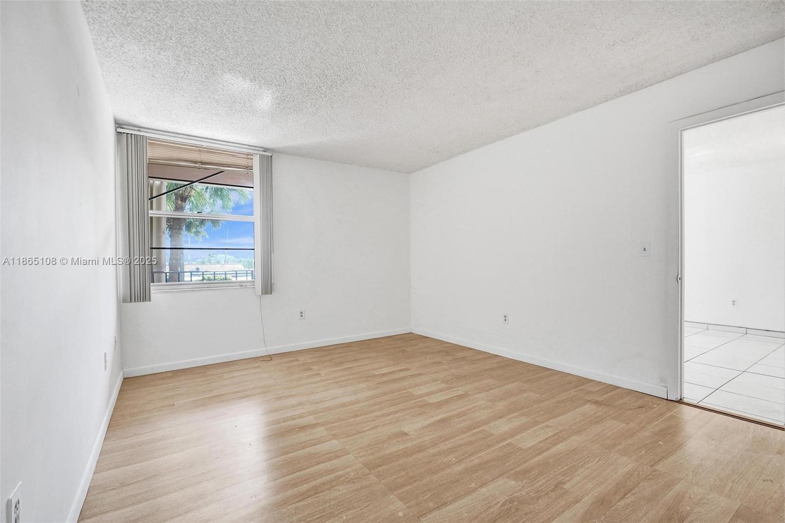 1900 West 68th Street, Unit C203 Hialeah, FL 33014 - Photo 11 of 29 an empty room with wooden floor and windows