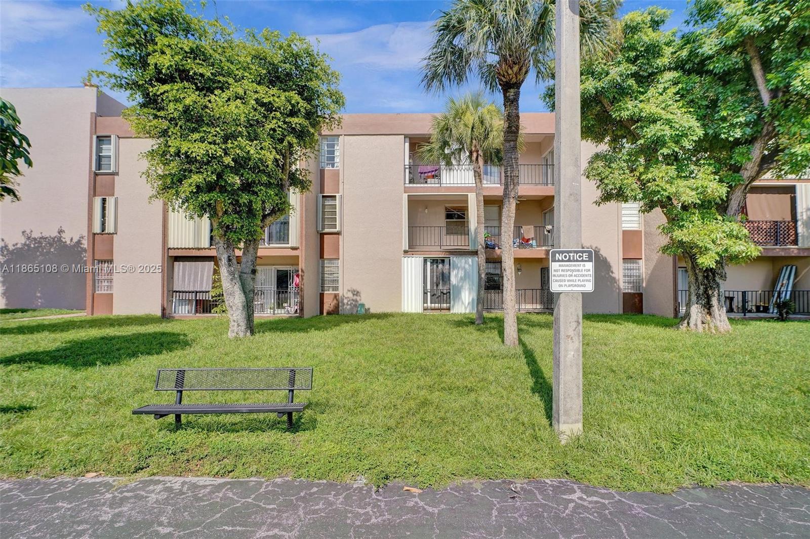 1900 West 68th Street, Unit C203 Hialeah, FL 33014 - Photo 28 of 29 a garden with trees in front of it