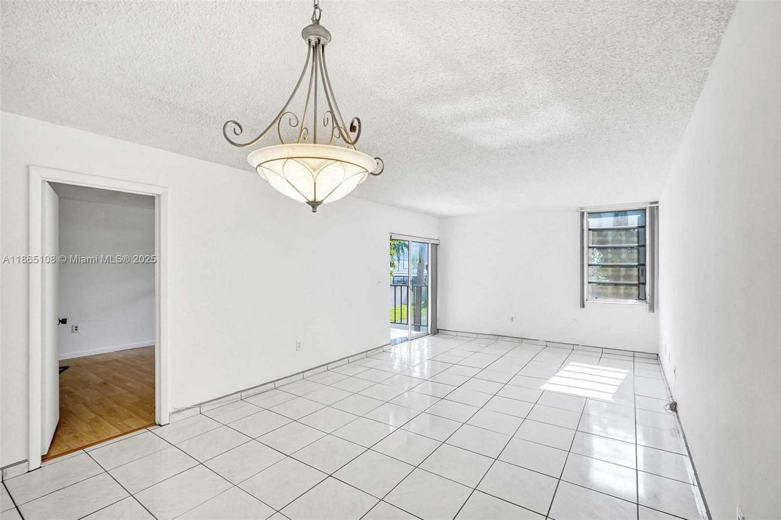 1900 West 68th Street, Unit C203 Hialeah, FL 33014 - Photo 4 of 29 a view of a room with a chandelier fan and windows