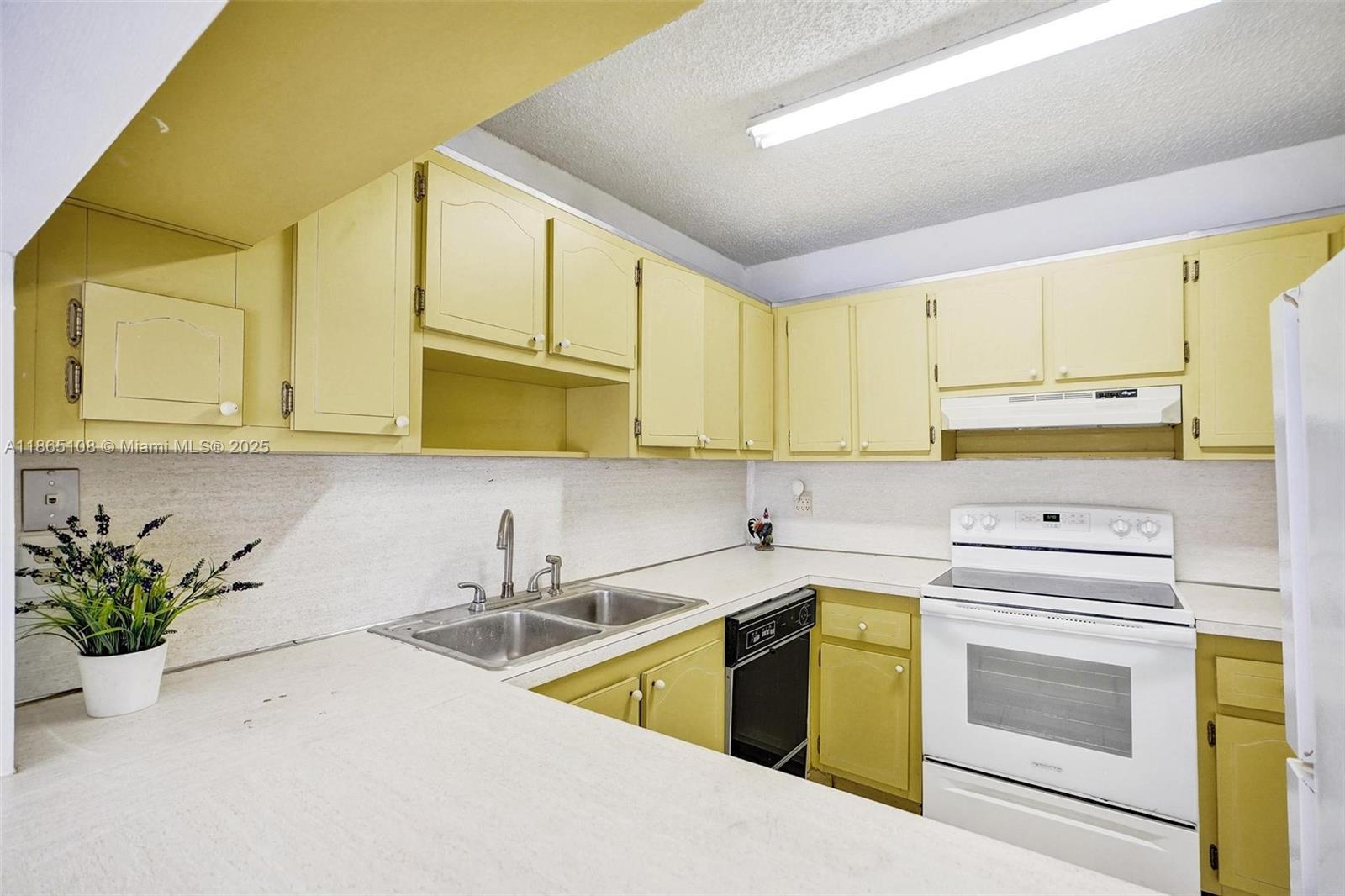 1900 West 68th Street, Unit C203 Hialeah, FL 33014 - Photo 7 of 29 a kitchen with stainless steel appliances white cabinets and a sink