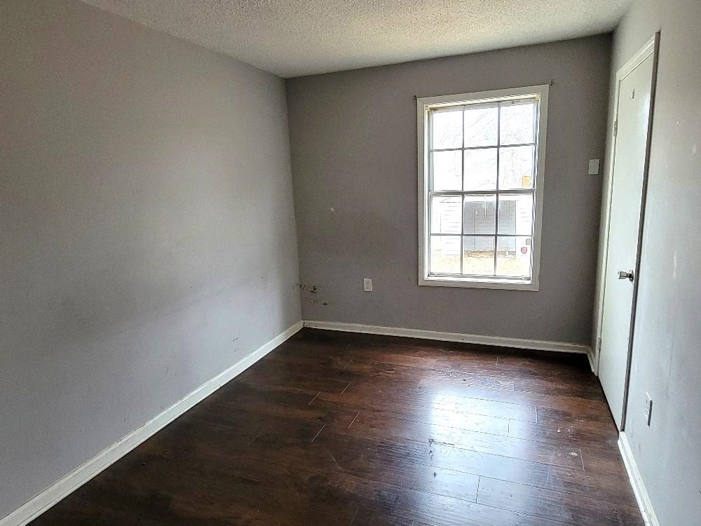 4063 Double Tree Road Memphis, TN 38109 - Photo 11 of 14 Unfurnished room featuring a textured ceiling and dark wood-type flooring