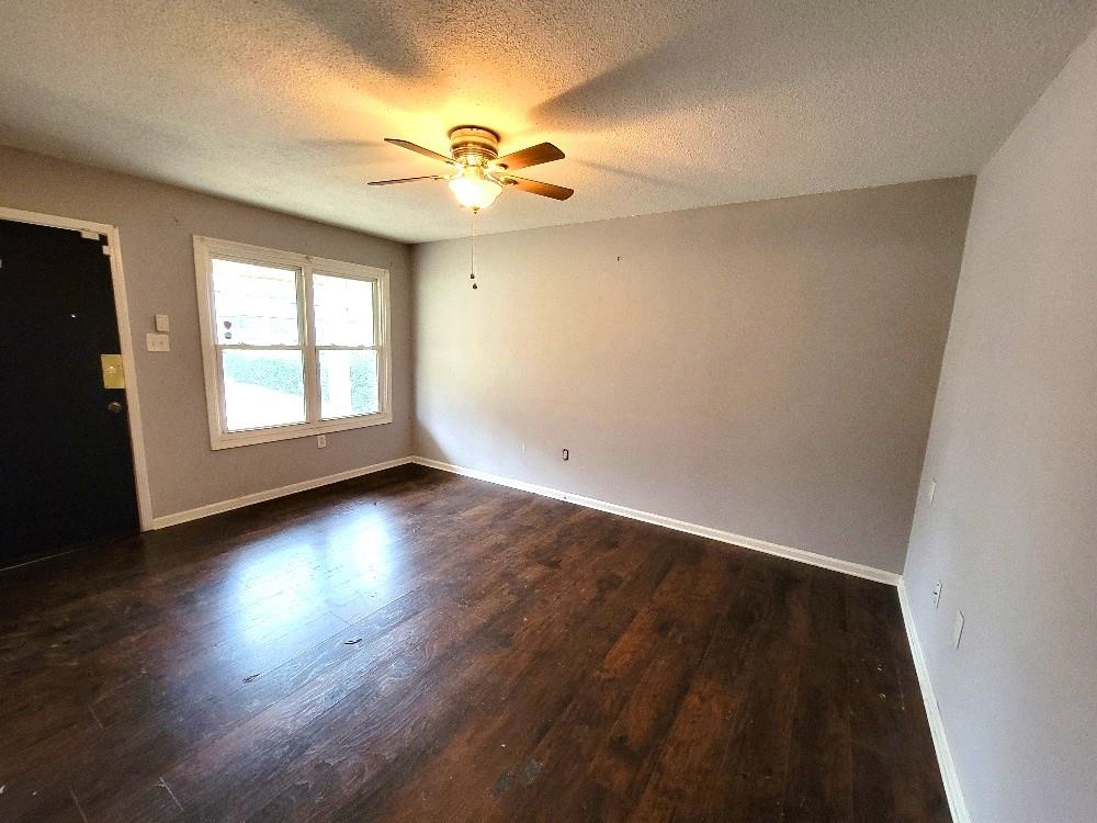 4063 Double Tree Road Memphis, TN 38109 - Photo 2 of 14 Spare room featuring a textured ceiling, ceiling fan, and dark wood-type flooring