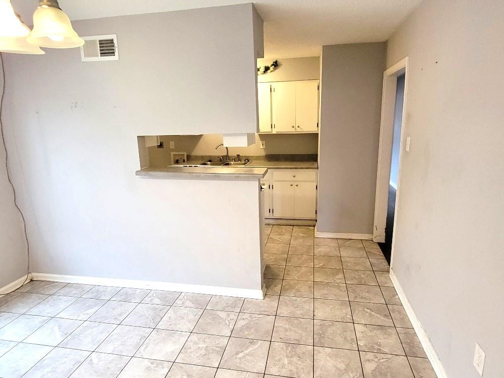 4063 Double Tree Road Memphis, TN 38109 - Photo 5 of 14 Kitchen featuring sink, white cabinets, pendant lighting, and light tile patterned floors