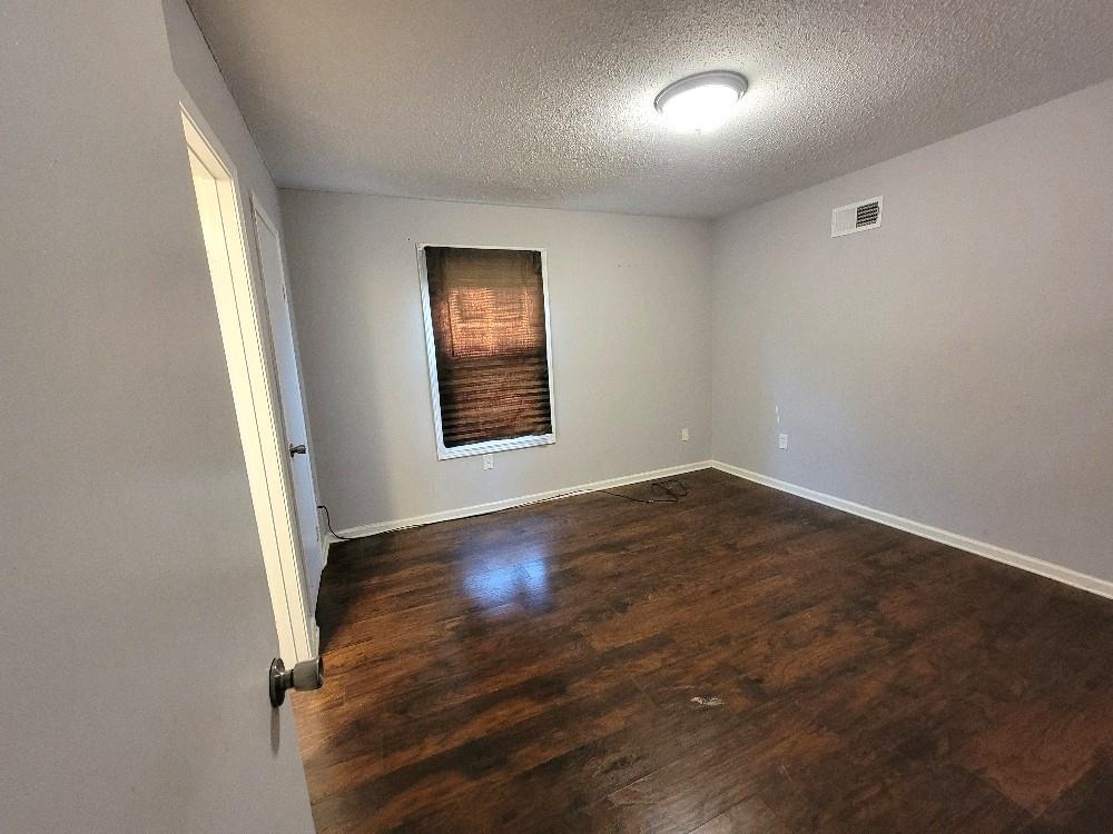 4063 Double Tree Road Memphis, TN 38109 - Photo 8 of 14 Unfurnished room with a textured ceiling and dark wood-type flooring
