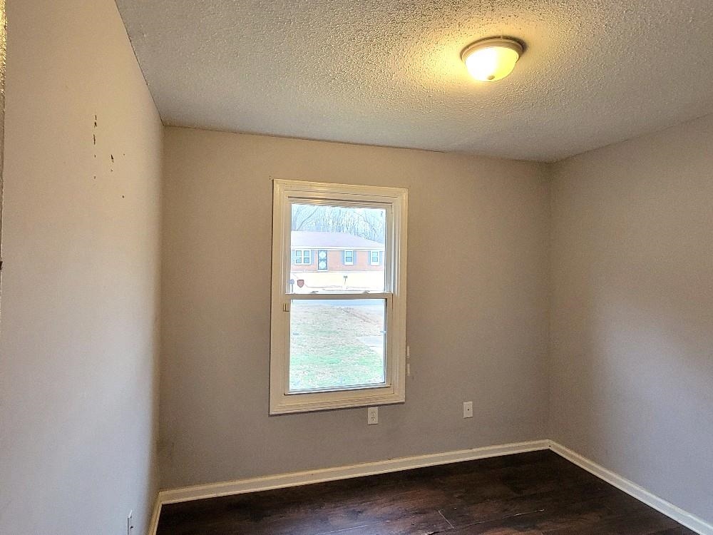 4063 Double Tree Road Memphis, TN 38109 - Photo 10 of 14 Unfurnished room with a textured ceiling and dark hardwood / wood-style floors
