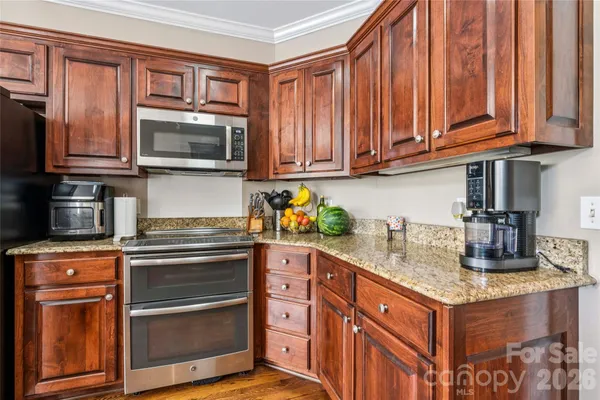 a kitchen with stainless steel appliances granite countertop a refrigerator and a stove