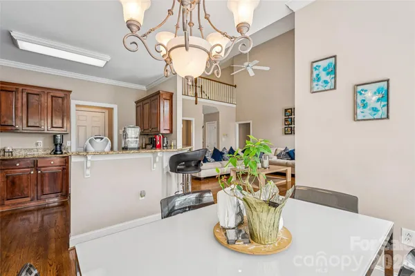 a dining room with furniture a chandelier and wooden floor