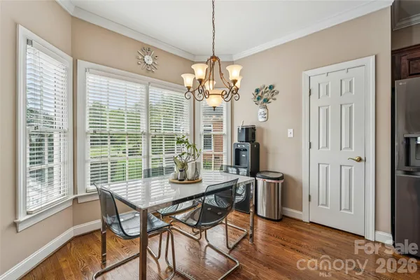 a view of a dining room with furniture wooden floor and chandelier