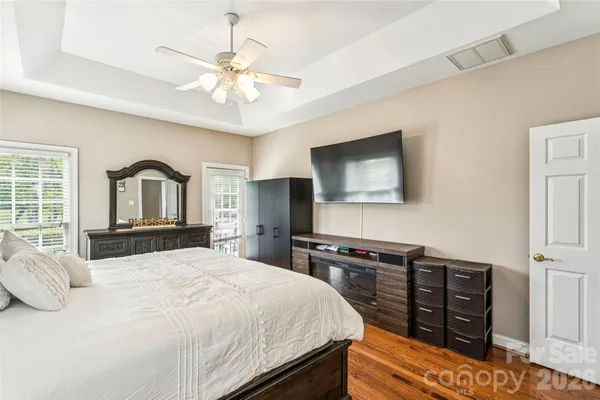 a bedroom with a bed and a flat tv screen on dresser
