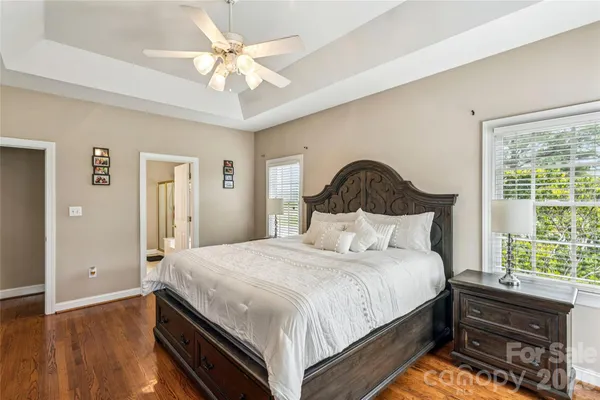 a bedroom with a bed and a dresser with wooden floor