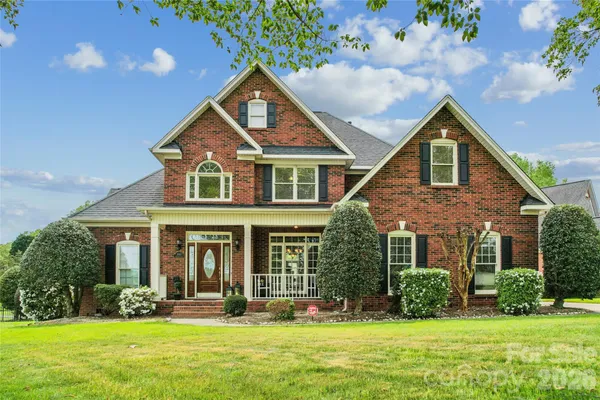 a front view of a house with yard and green space