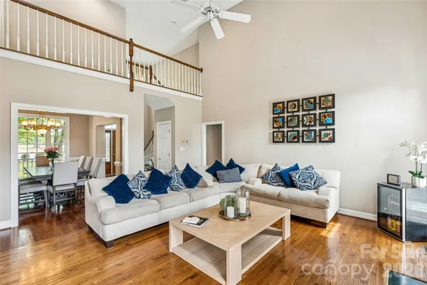 a dining room with wooden floor furniture and a chandelier