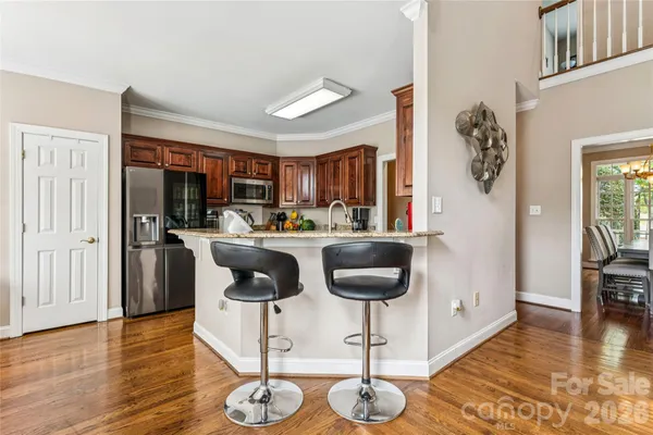 a kitchen with granite countertop stainless steel appliances wooden cabinets a sink and a window