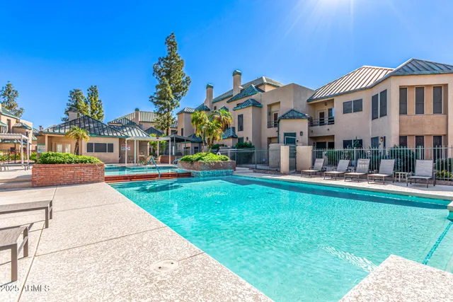 a front view of a house with fountain and potted plants