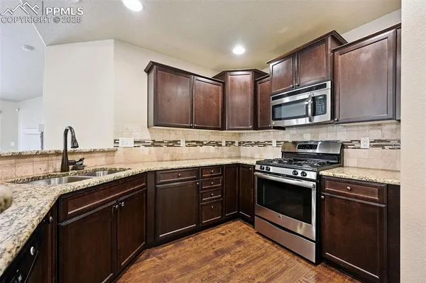 a kitchen with stainless steel appliances granite countertop a stove sink and cabinets
