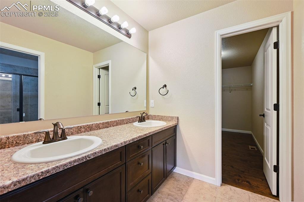 5384 Oak Spring Heights Colorado Springs, CO 80923 - Photo 14 of 19 a bathroom with a granite countertop sink and a mirror
