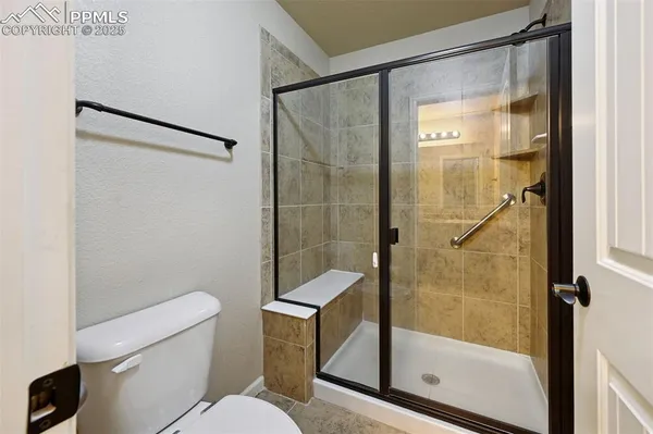 a bathroom with a shower a toilet and a sink