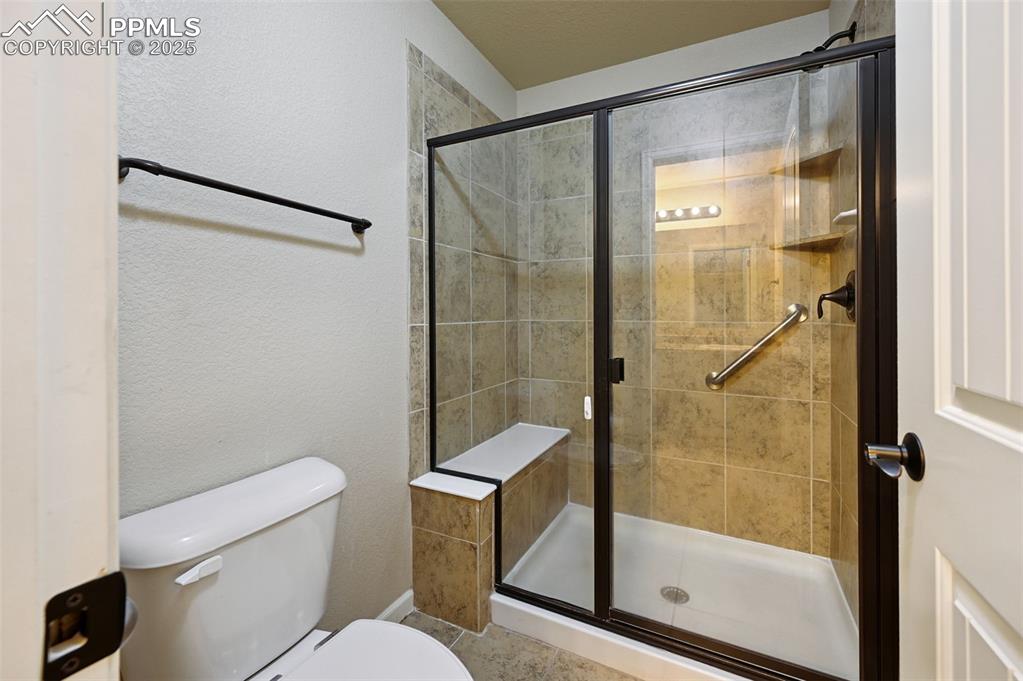 5384 Oak Spring Heights Colorado Springs, CO 80923 - Photo 15 of 19 a bathroom with a shower a toilet and a sink