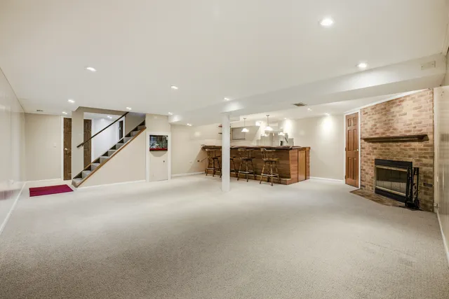 a view of an empty room with fireplace and stairs