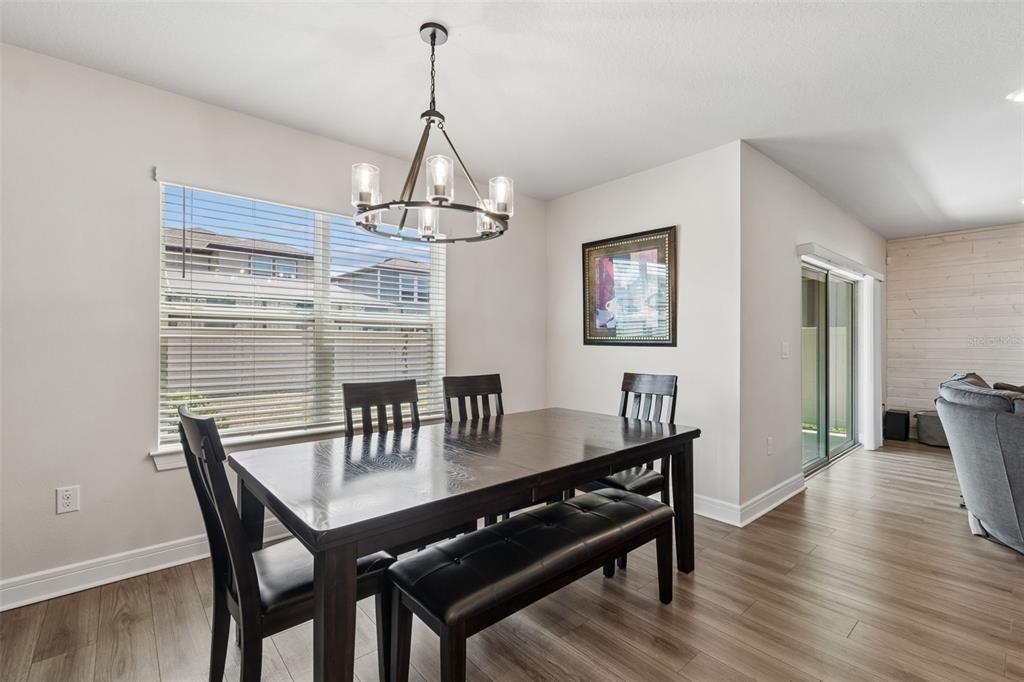 6608 Ryestone Way Wesley Chapel, FL 33545 - Photo 16 of 66 a view of a dining room with furniture wooden floor and chandelier