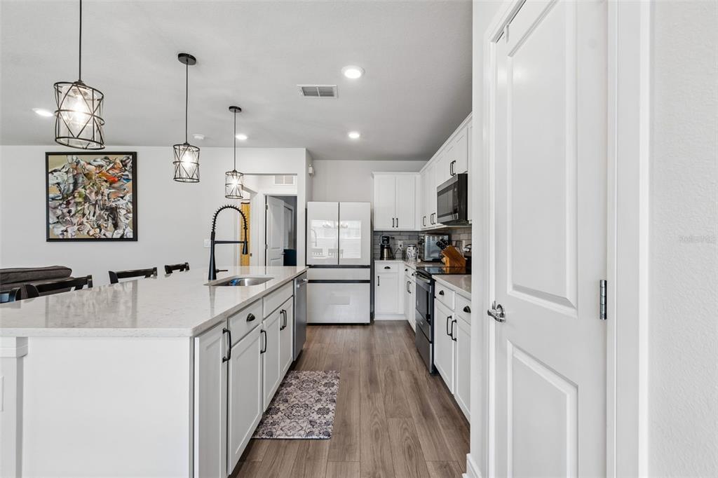 6608 Ryestone Way Wesley Chapel, FL 33545 - Photo 18 of 66 a kitchen with kitchen island granite countertop a sink appliances cabinets and a counter top space